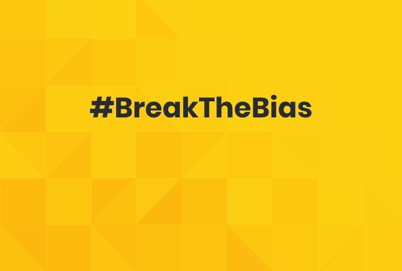Black text on yellow patterned background saying #BreakTheBias.
